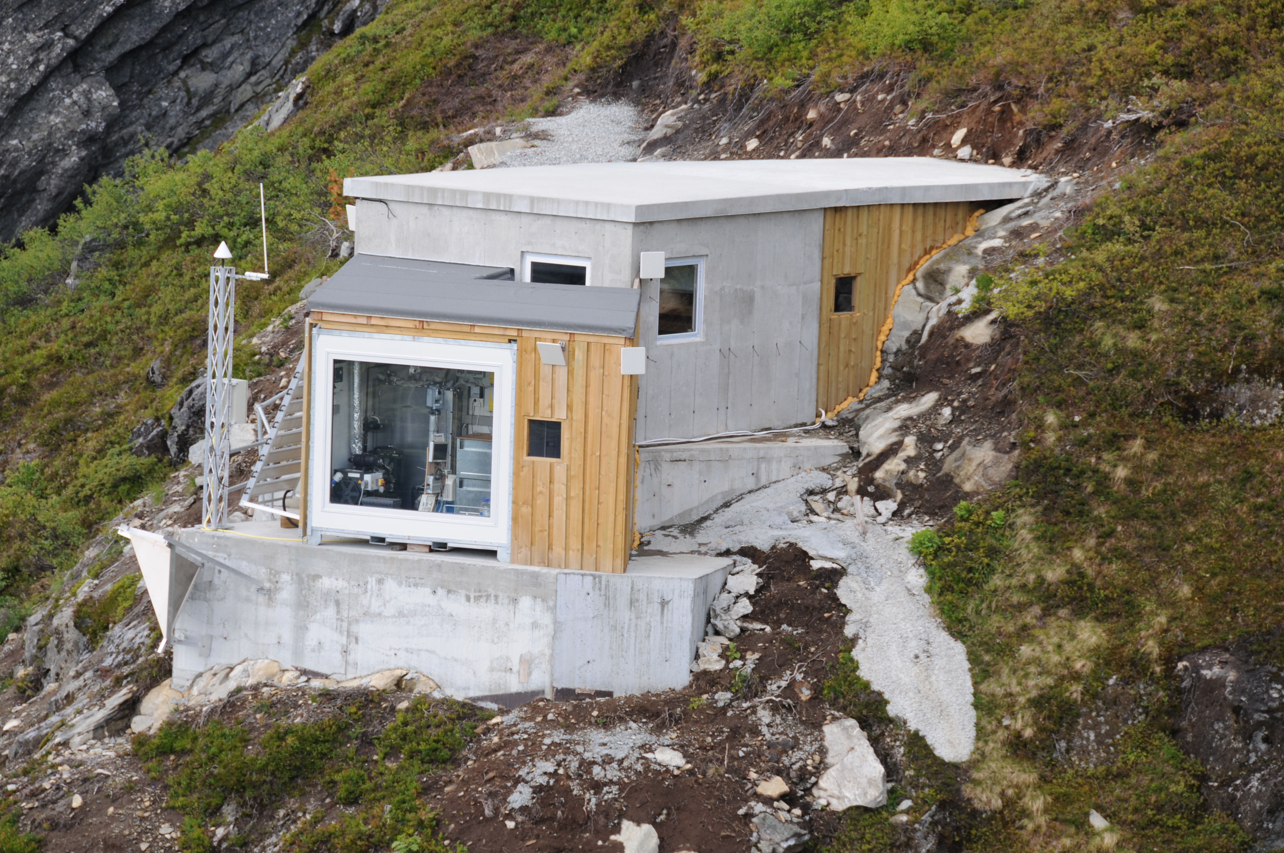 Fjellvåken med totalstasjonen bakenfor glasset som har full oversikt til prismene på Åknes. Foto: T. Bergeng/NVE