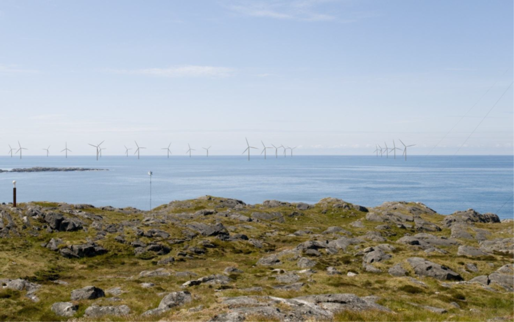 En fotorealistisk visualisering av et vindkraftverk til havs sett i motlys uten dis i luften. Visualiseringen har tatt høyde for at nærmeste turbin er 6 kilometer unna land og at hver vindturbin har en effekt på 10 MW. Totalhøyden er omtrent 190 meter Kilde: Førde et al. (2012) (4).